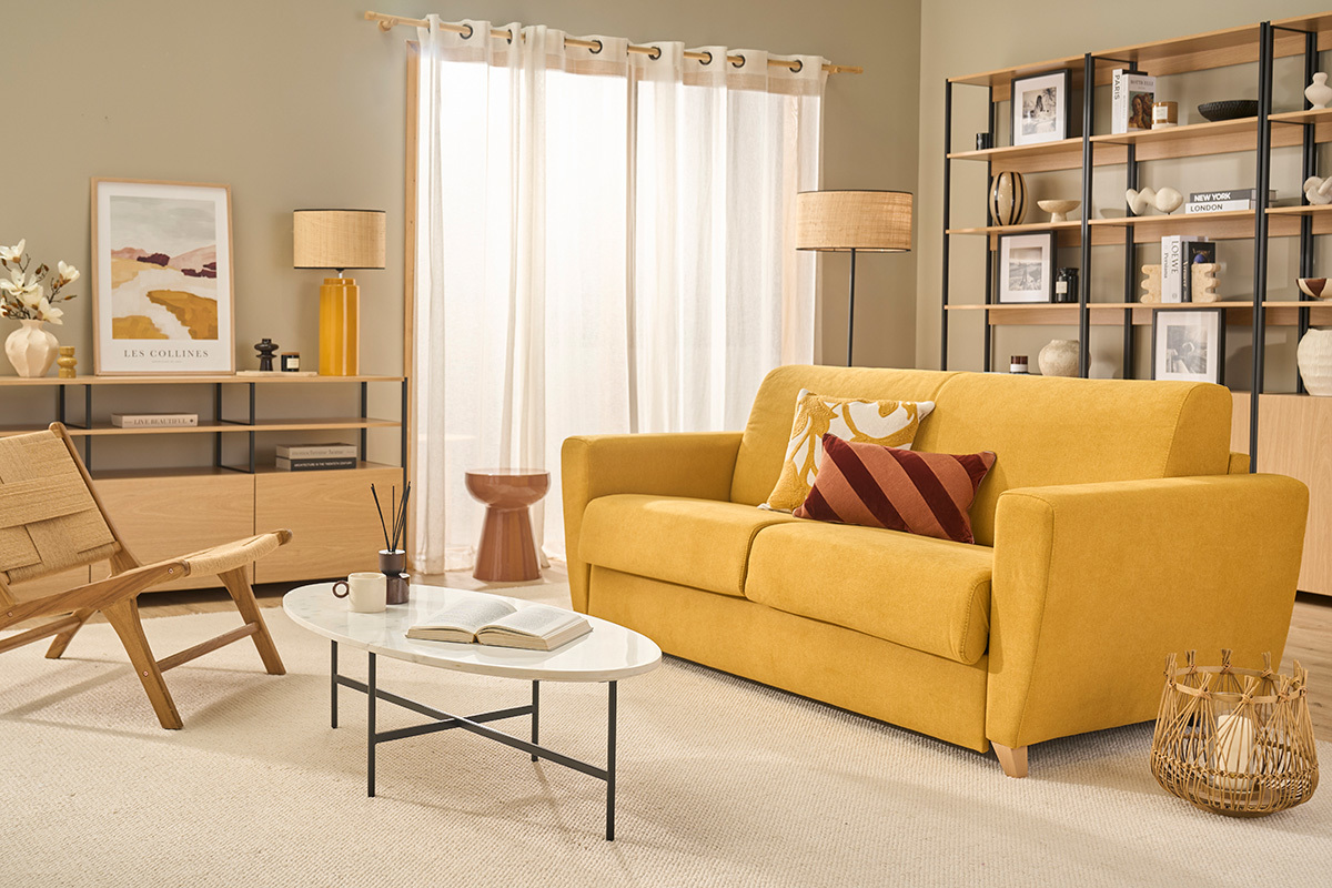 Canap� convertible 3 places jaune moutarde en tissu, angle de face dans un salon moderne.