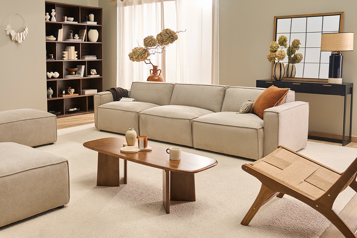 Canap� modulable 4 places beige en tissu effet velours dans un salon moderne avec table basse en bois.