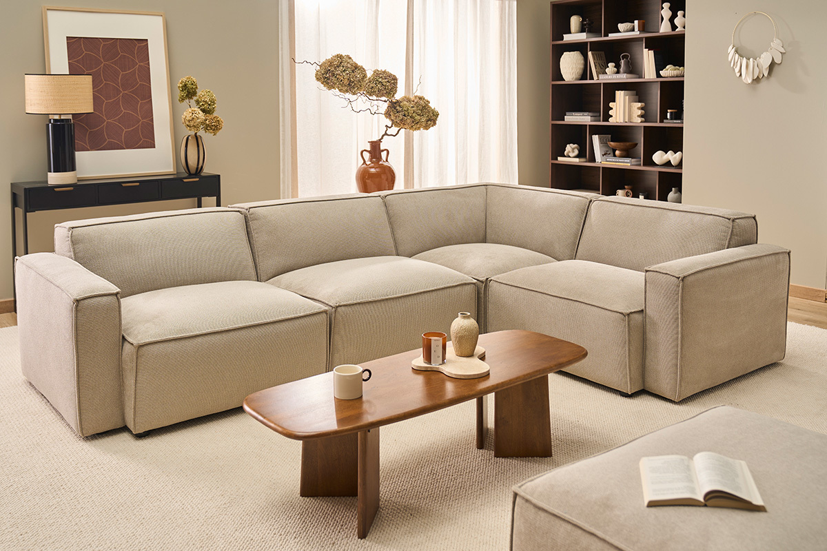 Canap� en tissu chenille beige avec table basse en bois, vue salon.