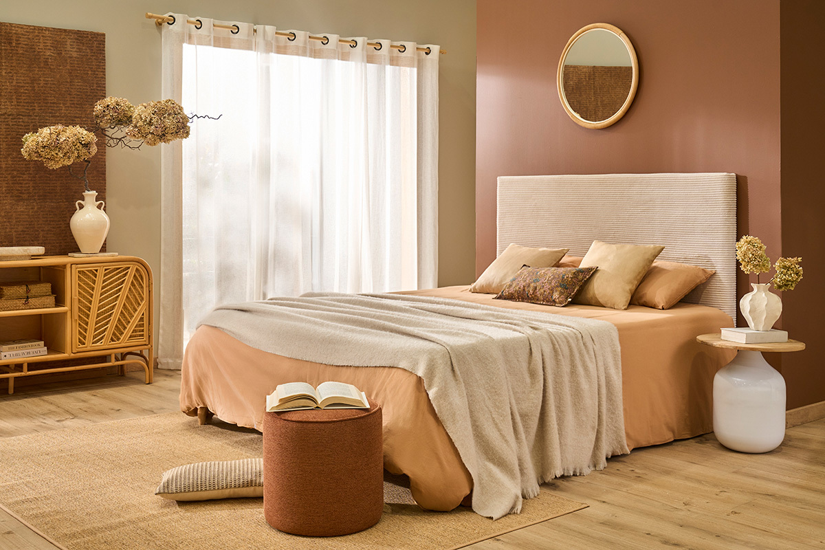 Pouf rond en tissu velours terre br�l�e D40 cm dans une chambre avec lit et d�coration naturelle.