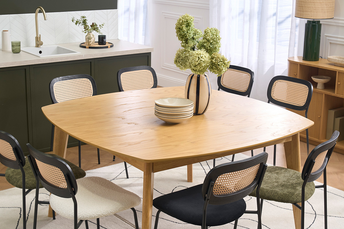 Table � manger carr�e en bois clair avec des chaises autour, d�cor�e de fleurs et vaisselle.