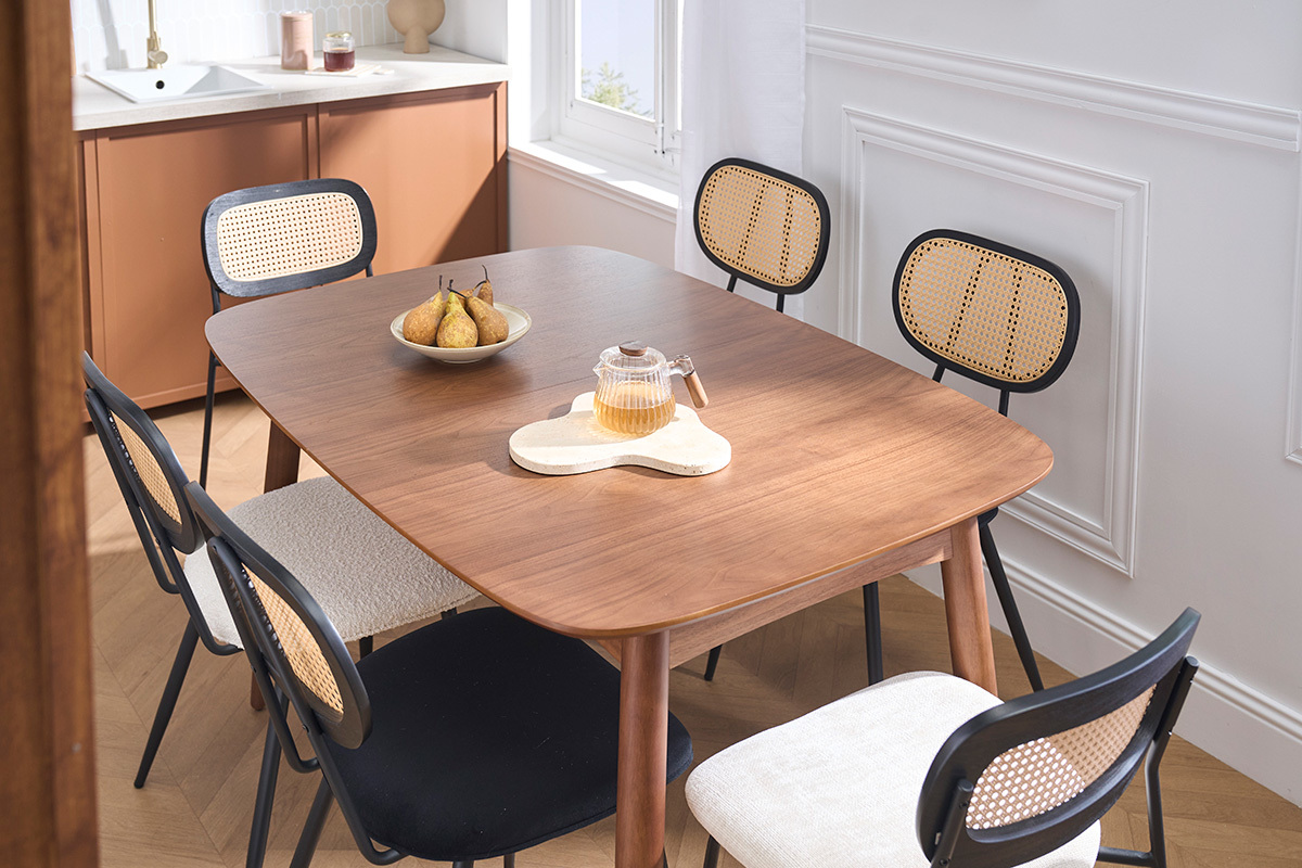 Table � manger extensible NORDECO en noyer, vue de trois quarts avec des chaises et des fruits sur la table.