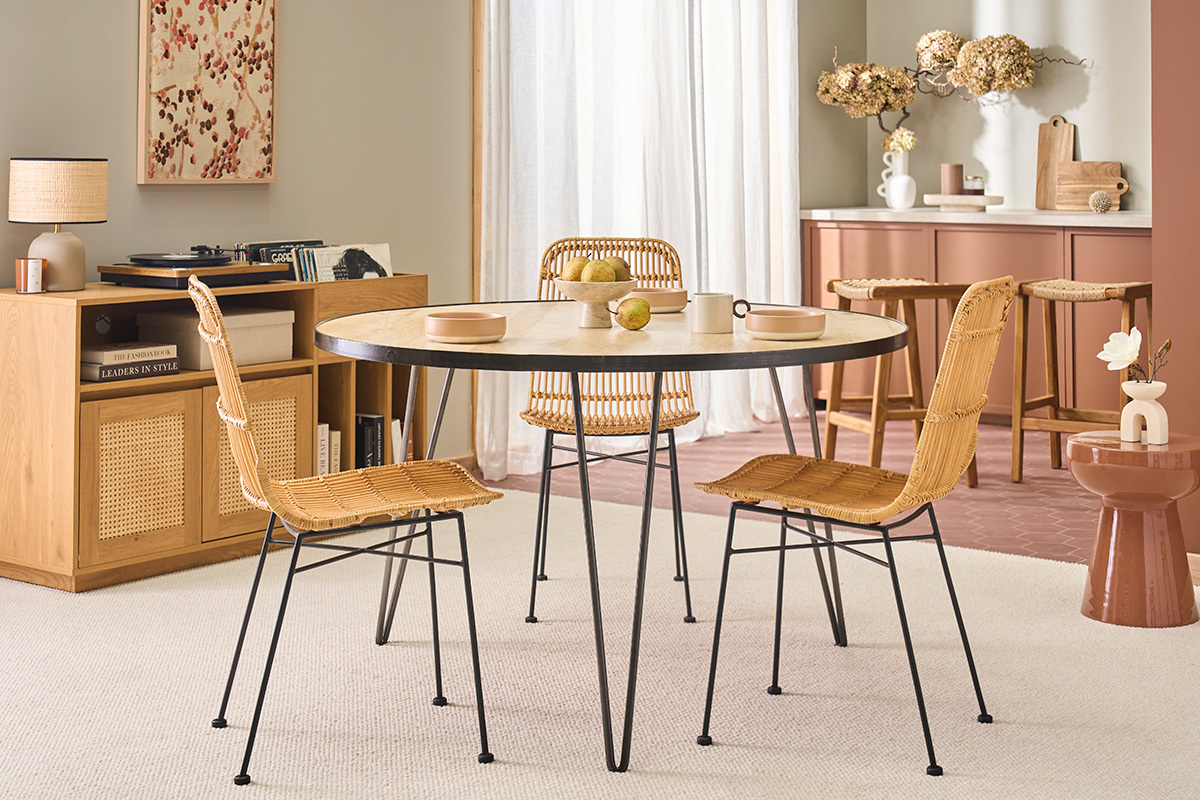 Table ronde en bois de manguier avec pieds en m�tal dans un int�rieur avec chaises assorties.