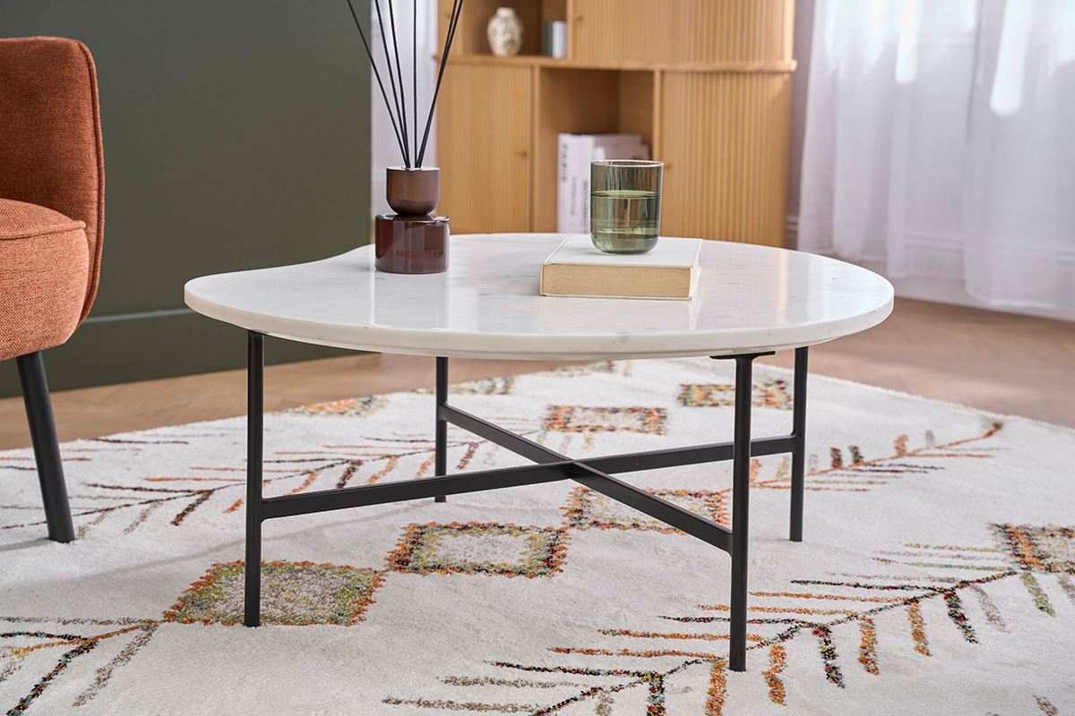 Table basse en marbre blanc et m�tal noir SASSO avec livre et verre, vue de c�t�.