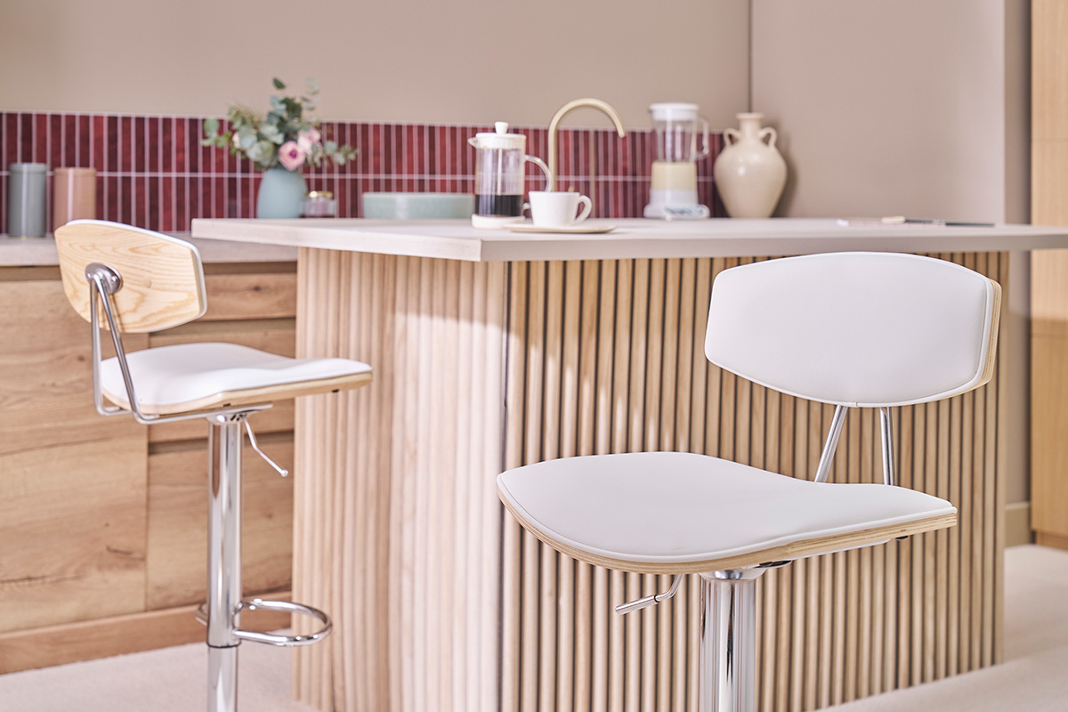 Deux tabourets de bar design blancs et bois clair dans une cuisine moderne.
