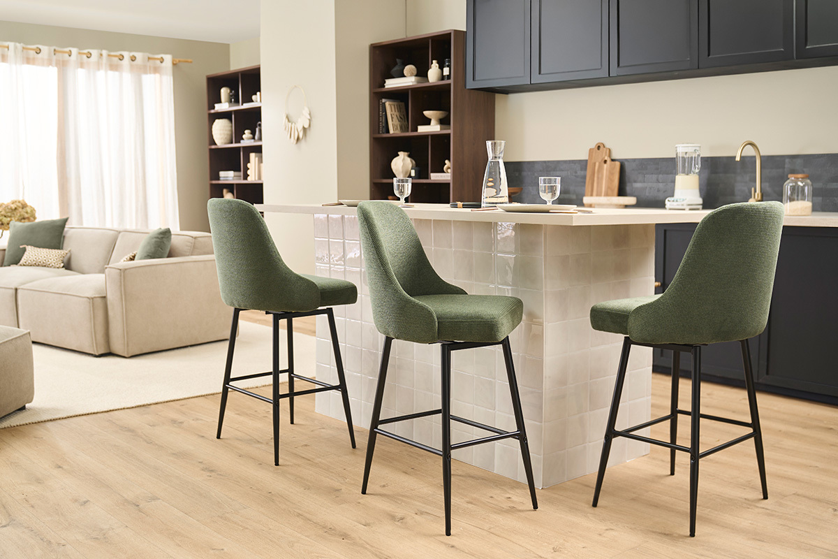 Tabourets de bar vert kaki en tissu et m�tal noir autour d'un �lot de cuisine.