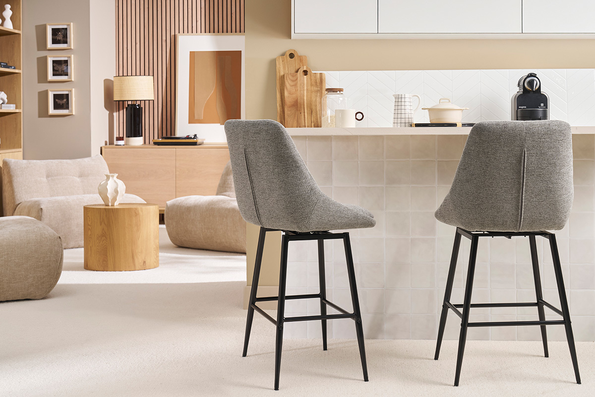 Deux tabourets de bar pivotants gris en tissu velours avec pieds en m�tal, vue de c�t� dans une cuisine moderne.