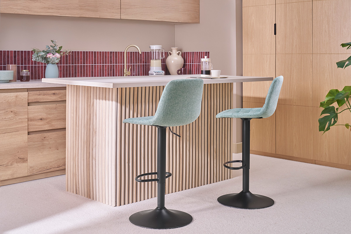 Tabourets r�glables c�ladon et m�tal devant un comptoir de cuisine en bois.